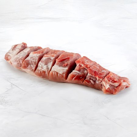 filetto di maiale tagliato su fondo marmo visto dal lato