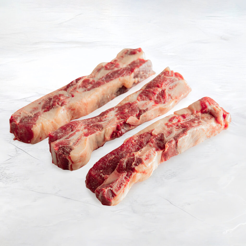 tre bistecche di asado dal colore rosso vivo su fondo marmo